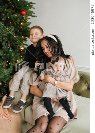 Joyful Mother Holding Baby With Son Smiling Nearby 133046972