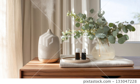 This cozy wellness space features a diffuser, essential oils, and fresh plants, perfect for stress relief and relaxation at home 133047228