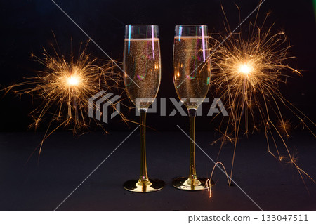 Celebration Toast. Two champagne flutes with sparklers on a dark background. Happy New Year Celebration Toast. Two champagne flutes with sparklers on a dark background. Happy New Year 133047511