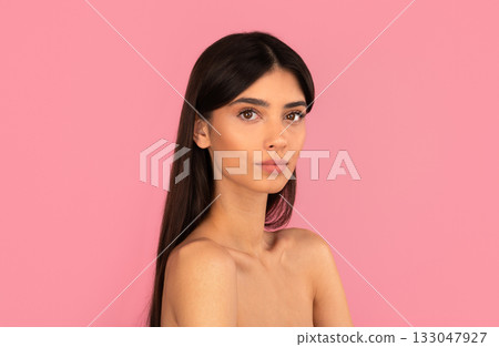 Beautiful woman with natural makeup and long hair posing against pink background Beautiful woman with natural makeup and long hair posing against pink background 133047927