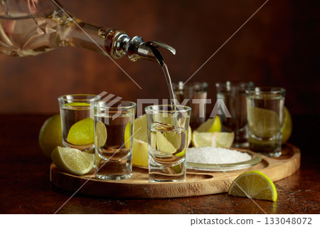 Gold tequila with salt and lime slices. 133048072