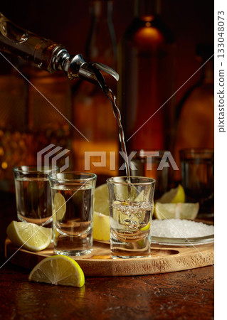 Gold tequila with salt and lime slices. 133048073