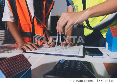 Closeup of team of industrial engineers meeting analyze machinery blueprints consult project on table in manufacturing factory. Working in manufacturing plant or production plant. 133048150