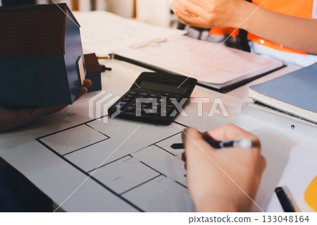 Closeup of team of industrial engineers meeting analyze machinery blueprints consult project on table in manufacturing factory. Working in manufacturing plant or production plant. Closeup of team of industrial engineers meeting analyze machinery blueprints consult project on table in manufacturing factory. Working in manufacturing plant or production plant. 133048164