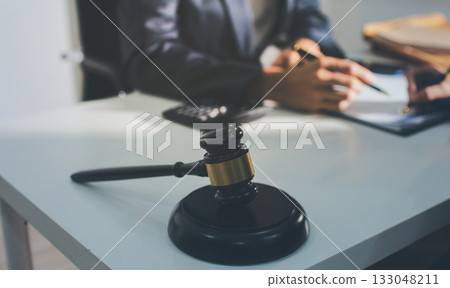 Lawyer explained to the client about the law that must be brought against the court case. Lawyer explained to the client about the law that must be brought against the court case. 133048211