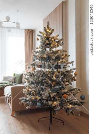 Festive Living Room with Snow-Flocked Christmas Tree and Cozy Decor 133048546