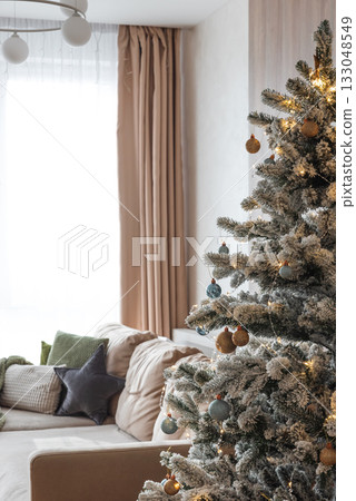 Festive Living Room with Snow-Flocked Christmas Tree and Cozy Decor 133048549