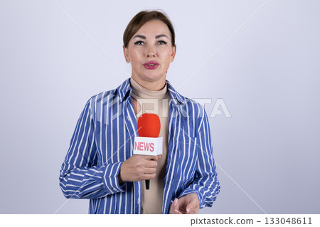 female reporter is presenting news or conducting an interview with a microphone 133048611