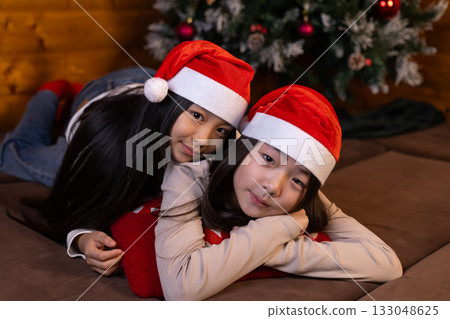 girls are excitedly looking at something festive, possibly Christmas presents 133048625
