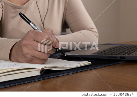 The journalist is diligently taking notes for an upcoming news report 133048654