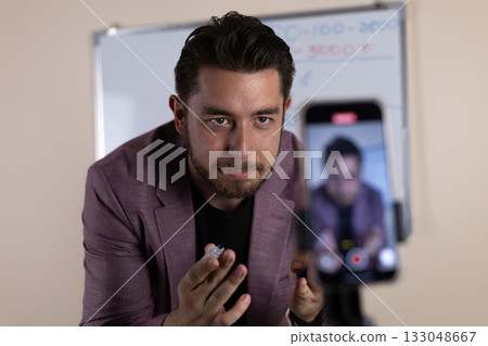 The man is recording a video blog post using his smartphone 133048667