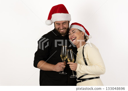 The couple is enjoying hot cocoa while wearing Santa hats for the Christmas The couple is enjoying hot cocoa while wearing Santa hats for the Christmas 133048696
