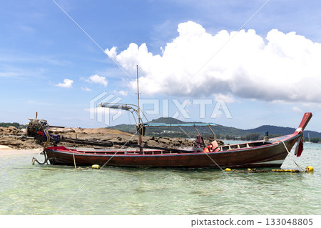 Traditional Thai longtail boats anchored on tropical beach with clear water and island landscape.  133048805
