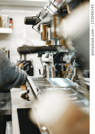 Barista preparing coffee in busy cafe during morning rush in downtown area 133049143