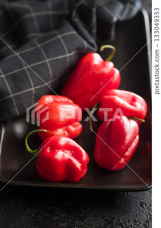 Red chili pepper habanero on plate on black table. 133049353