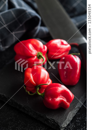 Red chili pepper habanero on black table. Red chili pepper habanero on black table. 133049354