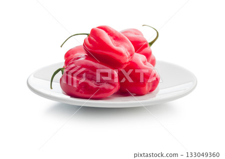 Red chili pepper habanero on plate isolated on white background. Red chili pepper habanero on plate isolated on white background. 133049360