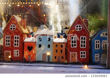 Garland and colorful ceramic houses in the window of a Christmas toy store 133049461