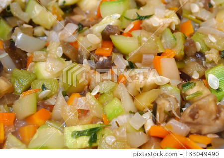 Vegetable stew is cooked on gas stove in metal pan. Vegetable ragout 133049490