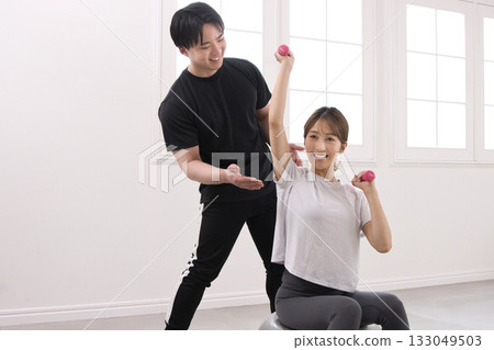Young woman receiving training from a personal trainer 133049503