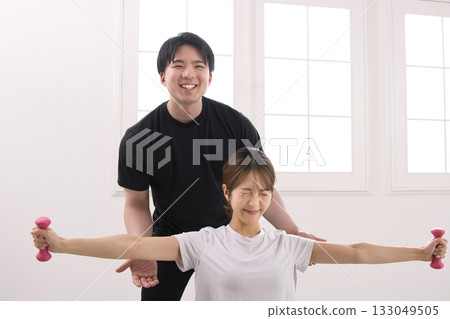 Young woman receiving training from a personal trainer 133049505