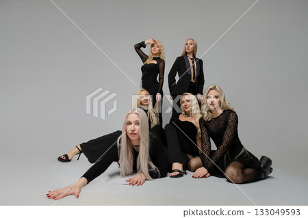 Group of women in black outfits posing creatively in a studio setting for fashion photography 133049593