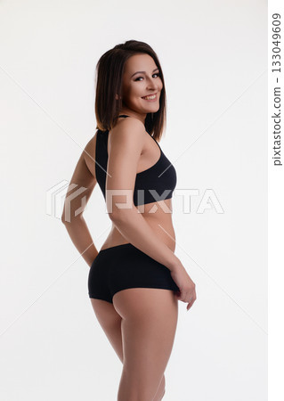 Woman posing in athletic wear against a plain background during a studio photoshoot Woman posing in athletic wear against a plain background during a studio photoshoot 133049609