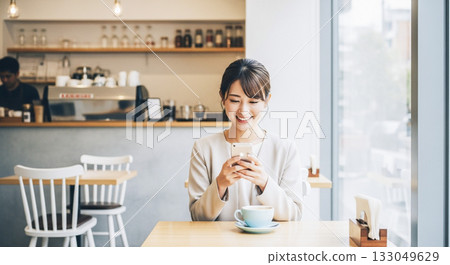 在咖啡館使用智慧型手機的年輕女子 133049629
