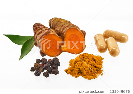 Turmeric and Spices Display. A display of turmeric root, powder, capsules, peppercorns, and leaves 133049676