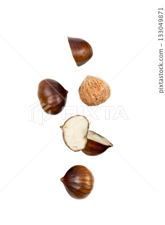 Falling edible sweet whole chestnuts, chest nuts in air isolated on white background Falling edible sweet whole chestnuts, chest nuts in air isolated on white background 133049871