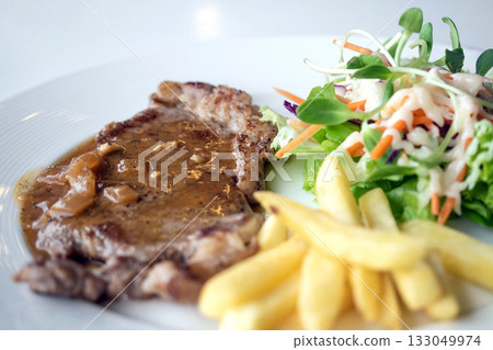 Close up of Grilled beef steak, boiled french fries and vegetable salad;Selective focus Close up of Grilled beef steak, boiled french fries and vegetable salad;Selective focus 133049974