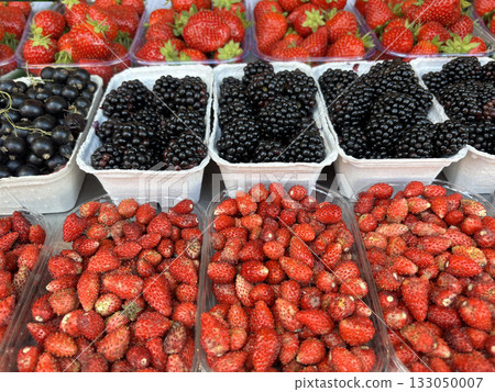 Fruit background with berry mix. Fresh juice blackberries and strawberries in market boxes Fruit background with berry mix. Fresh juice blackberries and strawberries in market boxes 133050007