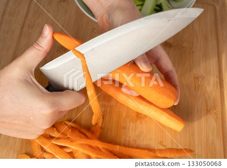 Fresh Carrot Peeling with Knife Close Up, Raw Carrot Slices, Orange Root Vegetable 133050068
