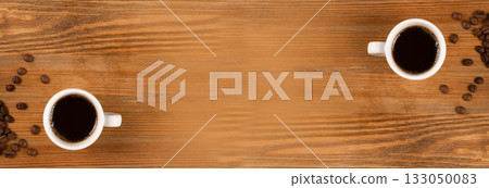 Hot coffee cup and coffee beans on brown background top view 133050083