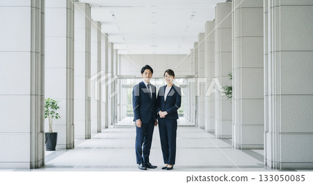 Male and female business people standing at the office entrance 133050085