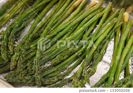 Cooked asparagus on a metal baking sheet. Roasted green vegetable for salad 133050208
