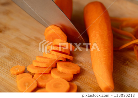 Cutting Fresh Carrot with Knife Close Up, Raw Carrot Slices Closeup, Orange Root Vegetable Cutting Fresh Carrot with Knife Close Up, Raw Carrot Slices Closeup, Orange Root Vegetable 133050218