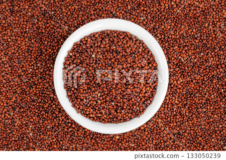 red quinoa seeds in ceramic bowl as a background. Top view. Flat lay 133050239