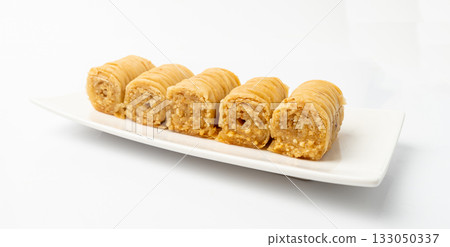 Rolled Baklava Isolated, Ramadan Dessert Roll on Restaurant Plate, Eastern Sweet Pastries Rolled Baklava Isolated, Ramadan Dessert Roll on Restaurant Plate, Eastern Sweet Pastries 133050337