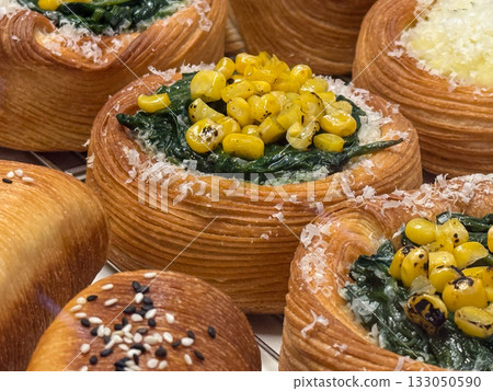 Spinach and corn Danish pastry with cheese shavings. Fusion of colors, textures, and taste in gourmet bakery presentation. Spinach and corn Danish pastry with cheese shavings. Fusion of colors, textures, and taste in gourmet bakery presentation. 133050590