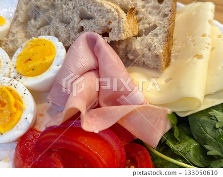 Morning plate with eggs, vegetables and bread on wooden table. Healthy diet, homemade breakfast, and natural nutrition balance. 133050610