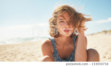 海邊，年輕女子的頭髮隨風飄揚。 133050738