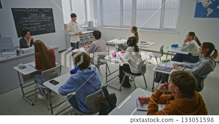 Students and Teacher Listen Attentively Presentation by One of Students 133051598