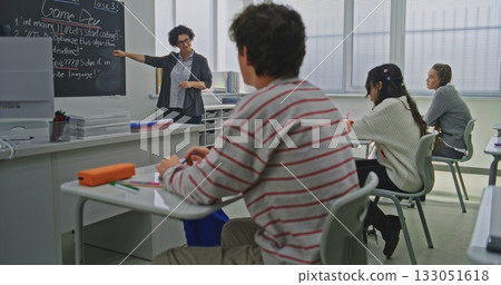 Confident Female Teacher Explains Coding Tasks to Students Confident Female Teacher Explains Coding Tasks to Students 133051618