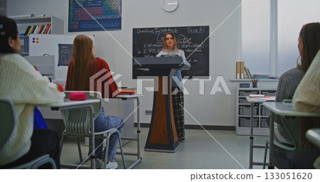 Young Woman Speaks Confidently at Podium, Smiling While Addressing Classmates and Teacher Young Woman Speaks Confidently at Podium, Smiling While Addressing Classmates and Teacher 133051620