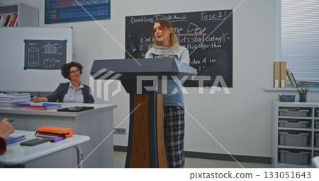 Young Woman Speaks Confidently at Podium, Smiling While Addressing Classmates and Teacher 133051643