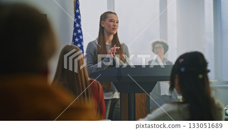 American Teenage Girl Delivers Expressive Speech, Gesturing Confidently With US Flag 133051689
