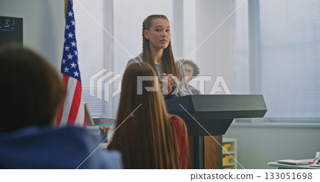 American Teenage Girl Delivers Expressive Speech, Gesturing Confidently With US Flag 133051698