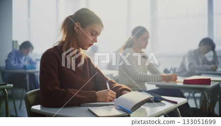 Teenagers Writing Completing Task in Classroom Teenagers Writing Completing Task in Classroom 133051699