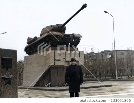 A vintage portrait of a middle-aged man wearing hat and coat in Dnipropetrovsk, Ukrainian SSR. Behind him is a monument to a tank that fought in battle to liberate city from Nazis in 1944. Retro 1990. A vintage portrait of a middle-aged man wearing hat and coat in Dnipropetrovsk, Ukrainian SSR. Behind him is a monument to a tank that fought in battle to liberate city from Nazis in 1944. Retro 1990. 133051866